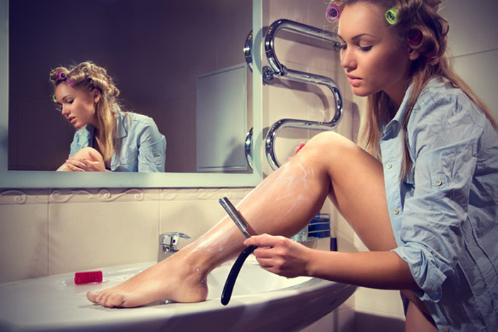 Woman-shaving-her-legs-in-the-bathroom