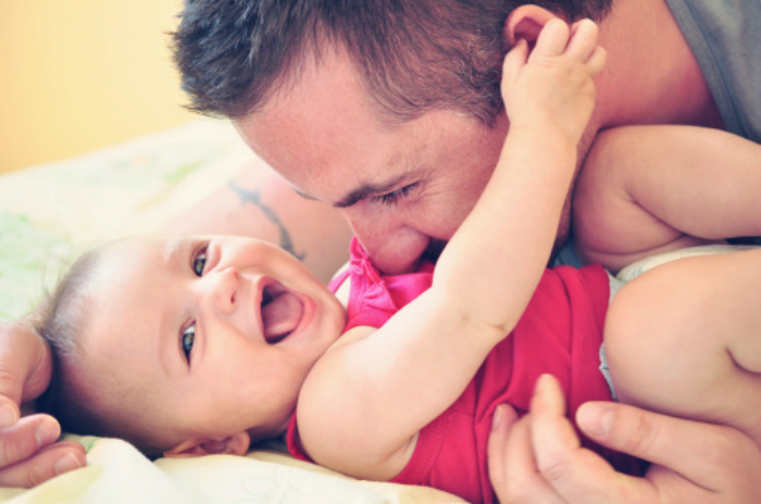 father_playing_with_his_happy_and_smiling_baby_daughter