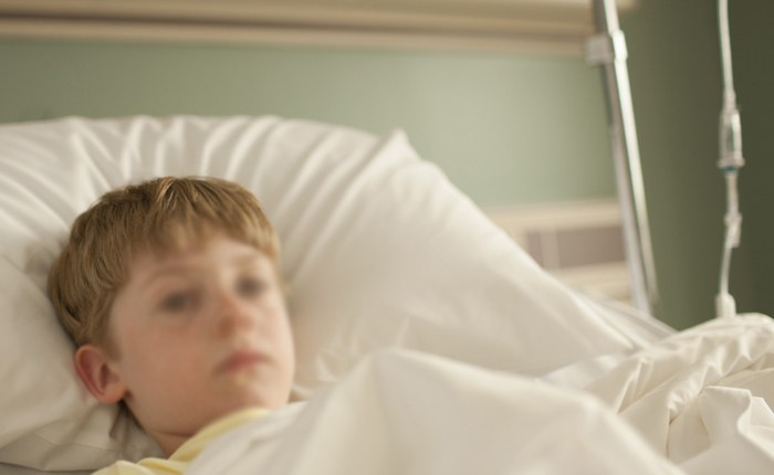 Young boy lying in hospital bed