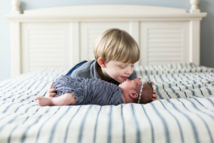 relaxed-newborn-session-brother-kissing-sister-in-home-bed-picture-52-500x333