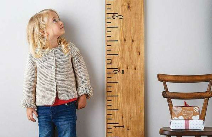 Girl-standing-by-measuring-stick