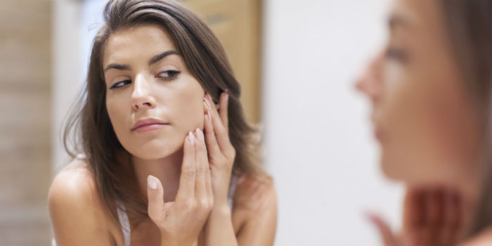 o-WOMAN-LOOKING-AT-ACNE-IN-MIRROR-facebook