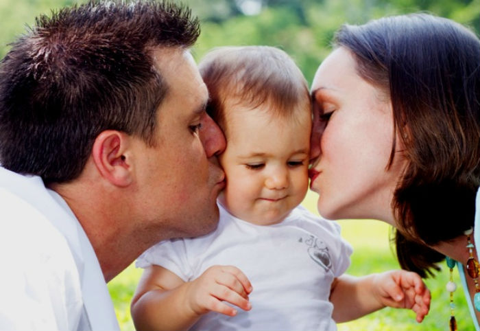 Becoming-new-parents_Mum-and-Dad-kissing-child_Mouths-of-Mums