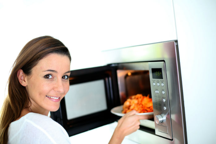 woman-with-food-next-to-microwave