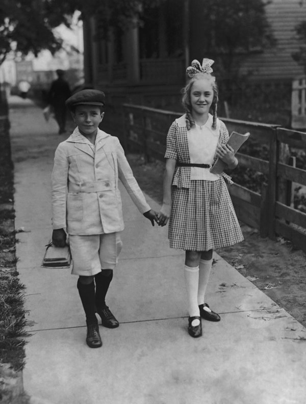 A young boy and girl on the way to school for the first day of a new term circa 1920. (Photo by Keystone View/FPG/Getty Images)