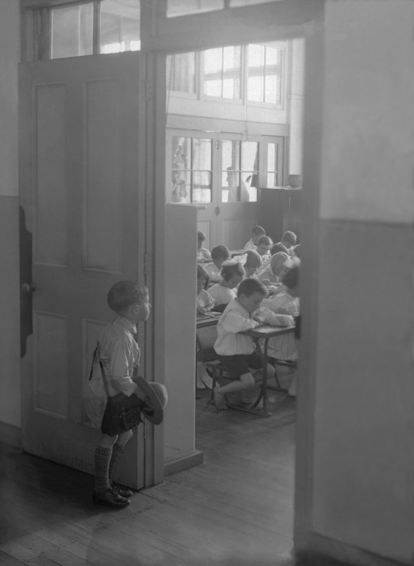 (AUSTRALIA OUT) A young boy stares into a classroom full of students on his first day of school, exact date unknown.  (Photo by Staff/Sydney Morning Herald/Fairfax Media via Getty Images)